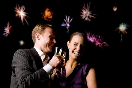 Couple Toasting At Party With Fireworks In Background