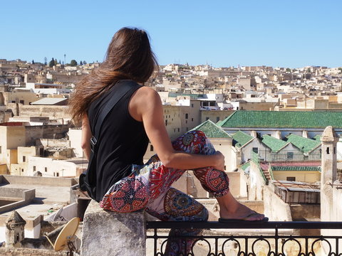 A girl sitting on the rooftop and observing the ancient Fes Medina Fes el-Bali