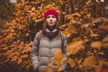 Young woman in casual wear standing in autumn forest.