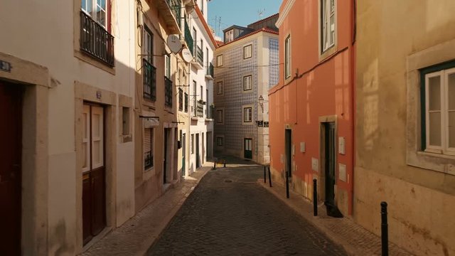 Walking along the unusually empty streets of Alfama, the oldest district of Lisbon, Portugal. Alfama has many important historical attractions along with Fado bars and restaurants.