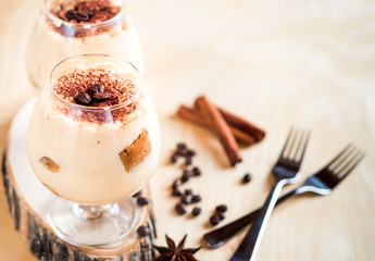 Exquisite Italian dessert tiramisu in cognac glasses on a white