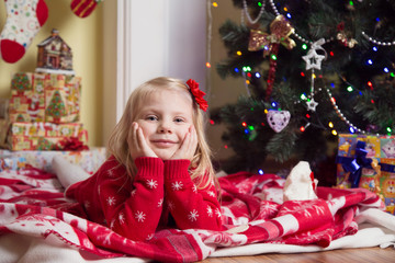 Happy little girl  under the Christmas tree