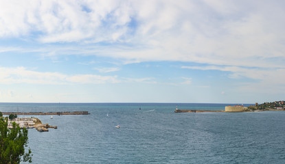 Small yachts float on near Konstantinovskaya battery, and a breakwater with a lighthouse at the exit from Sevastopol Bay