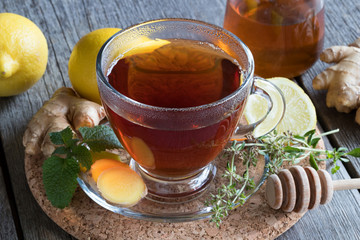 A cup of tea with ginger, lemon, herbs and honey
