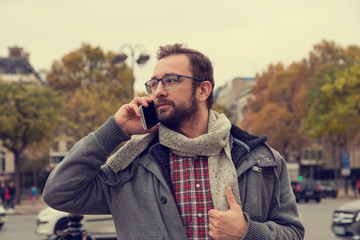 Young business man texting on her cellphone in the European city.