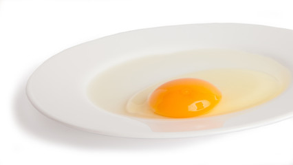 A fresh chicken egg, on the plate, isolated on a white background