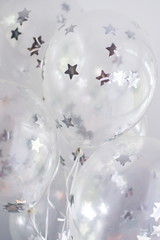 Flying white balloons with silver stars under the ceiling