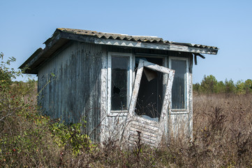 Abandoned and demolished wooden bungalow in summertime