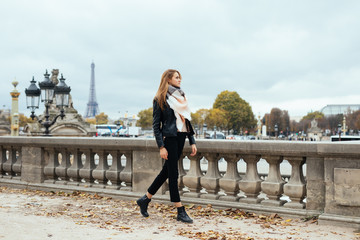 Beautiful Parisian girl walking near the Eiffel tower. Woman walking on Paris street