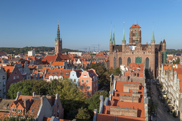 Fototapeta premium Old residential buildings, Main Town Hall's tower, Mariacka Street and St. Mary's Church at the Main Town (Old Town) in Gdansk, Poland, viewed from above on a sunny day.