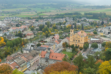 Fototapeta na wymiar Mesmerising top view on the Parish church in the autumnal city Brunico from the tower of Bruneck castle in Alto Adige, Italy, Europe