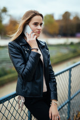 Closeup portrait of enjoyed brunette girl speaking on phone on street.