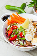 Noodles with beef meat, chili peppers and mushrooms in bowl on grey stone background. Asian Cuisine Pasta. Top view. 