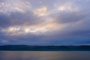 Fototapeta na wymiar Lake Scenery with Dramatic Sky Above
