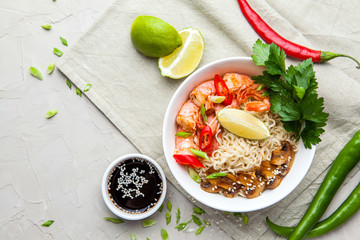 Noodles with shrimp, chili peppers and mushrooms in bowl on grey stone background. Asian Cuisine Pasta. Top view. 
