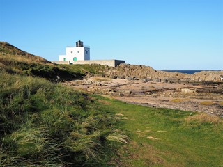 Fototapeta na wymiar Bamburgh lighthouse against a blue sky, Northumberland, England