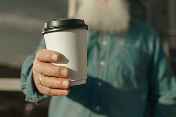 old man with beard and coffee in hand