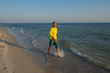 Happy traveler is walking along the surf line