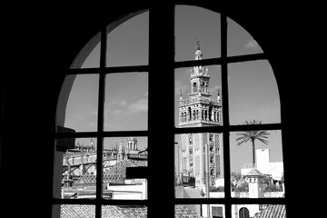 Vista de la Giralda, en la catedral de Sevilla, a través de una ventana, en blanco y negro, Andalucía, España