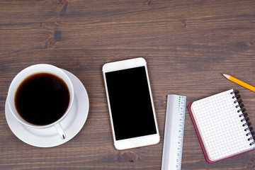 Top view of Cup of coffee with smart phone on wooden background. Technology, successful business and advertising concept