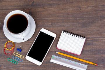 Top view of Cup of coffee with smart phone on wooden background. Technology, successful business and advertising concept