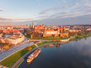 Drone aerial view at gold sunset time of royal Castle in Cracow  city center, Vistula river....
