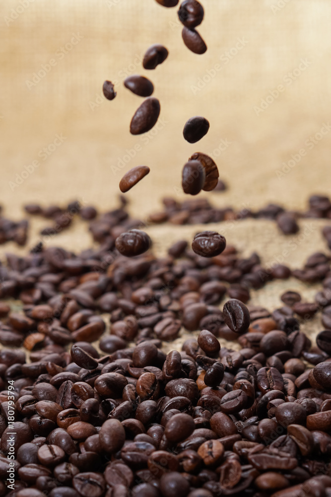 Wall mural Spilling out coffee beans from cup