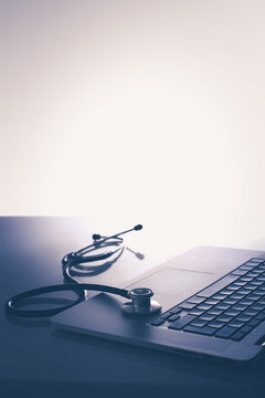 Workplace of doctor with laptop and stethoscope and notebook on white table
