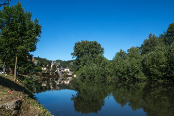 Village de Sainte Eulalie d' Olt en Aveyron se reflétant dans le Lot , France
