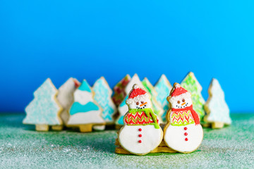 Christmas snowmans and trees ont eh background cookies winter composition.