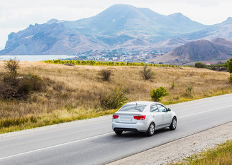 landscape with mountains, lake, road and car