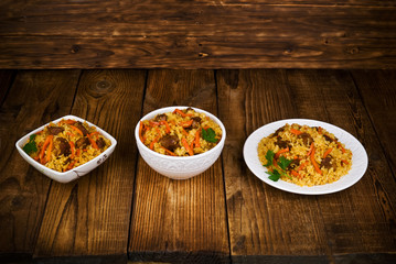 pilaf in a plate on wooden background