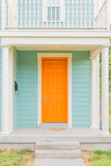 Bright colored front door of remodeled urban home, tangerine orange and light turquoise baby blue