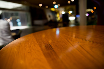 Empty wood table top on blur cafe restaurant in dark background/selective focus .For montage product display.