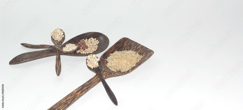 Wall mural grains in a wooden spoon on a white background.