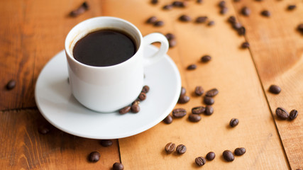 Fototapeta premium Coffee cup and coffee beans on wooden background