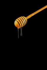 Spoon of honey. On a black background. Dripping fresh honey.