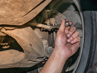 The mechanic using box wrench to manually alignment the wheel balance