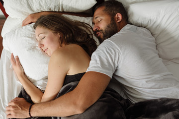 Black and white couple sleeping in bed