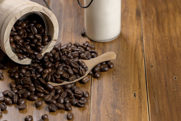Coffee bean grain ,bottle of milk and sack fabrice board on brown wood table background , include copyspace for add text or graphic in advertise or marketing content