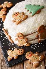 Christmas sweet cake with cheese cream and gingerbread close-up. vertical
