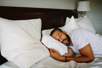 Black man sleeping in bed