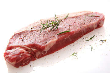 Fresh raw beef steak with pepper and rosemary isolated in white background