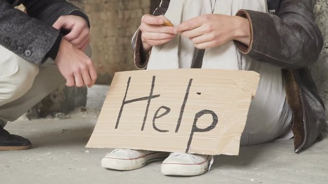 Rich man gives bitcoin to homeless and people shakes hands