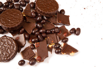 Dark chocolate with hazelnut, round chocolate chip cookies and chocolate dragee on clean white background