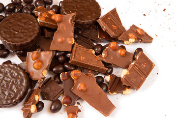 Dark and milk chocolate with hazelnut, round chocolate chip cookies and chocolate dragee on clean white background