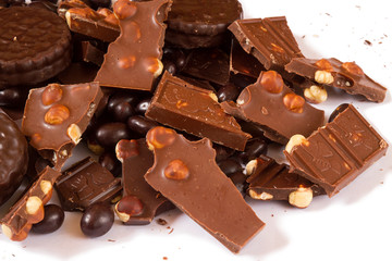 Dark and milk chocolate with hazelnut, round chocolate chip cookies and chocolate dragee on clean white background