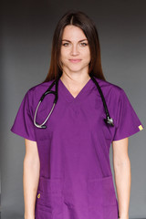 Nurse in scrubs on gray background
