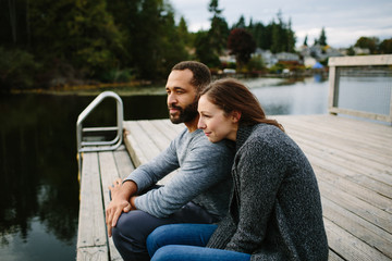 Black and white couple cuddling at the lake