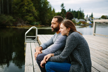 Black and white couple cuddling at the lake